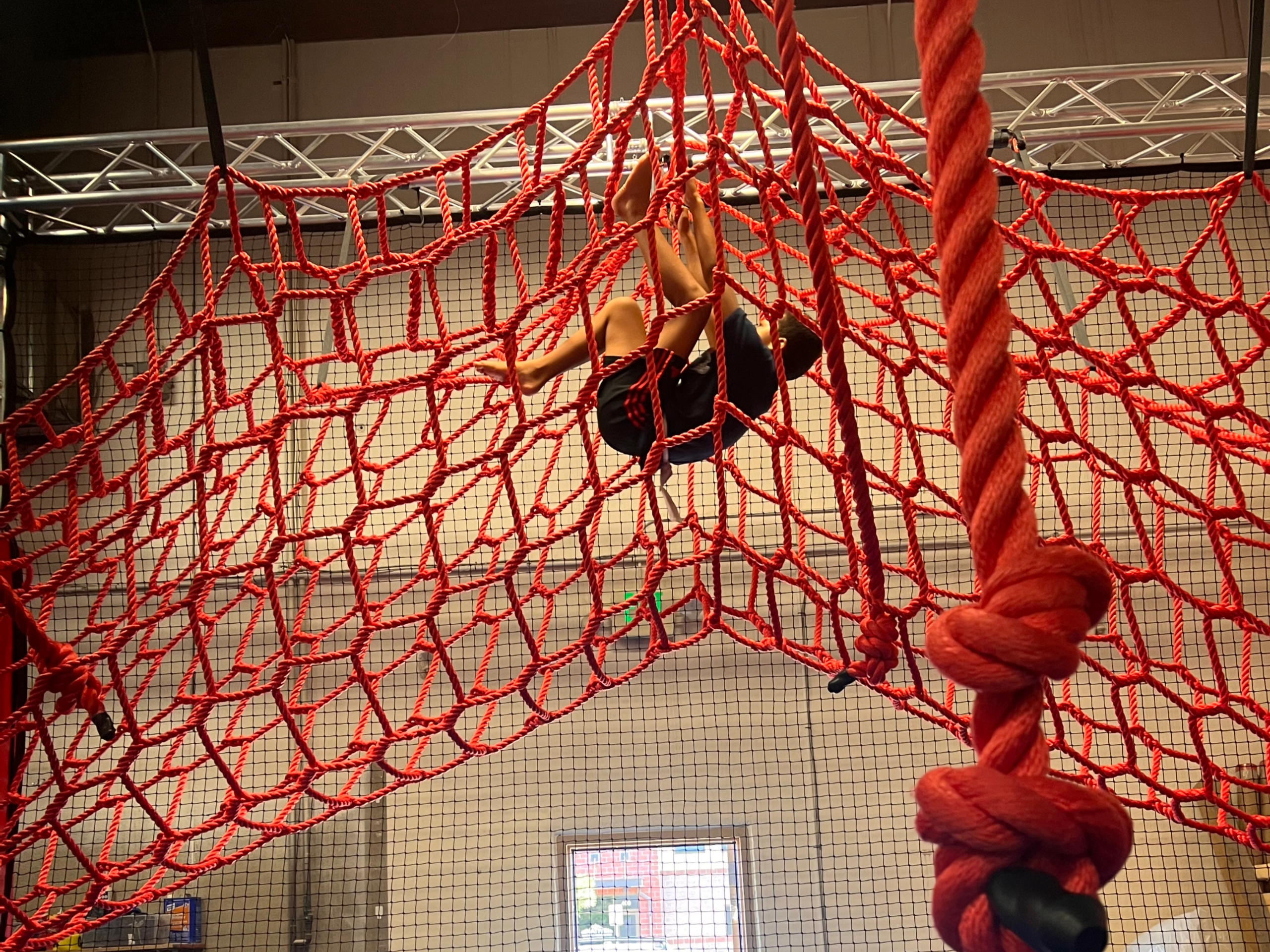 Kid climbing on net in obstacle course
