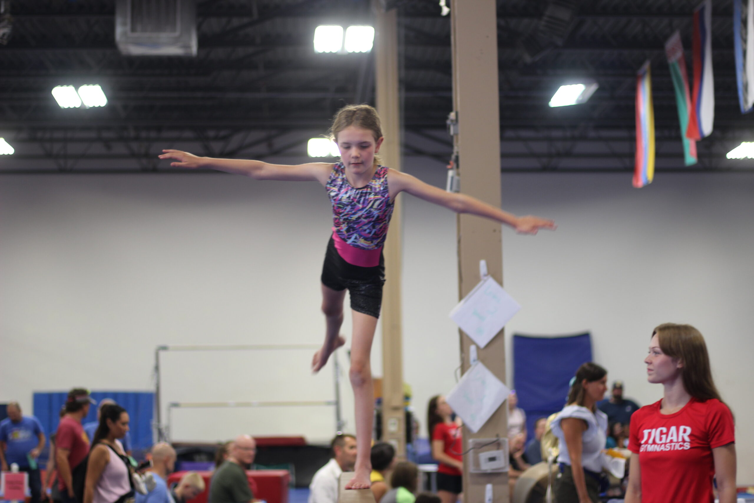 young girl hanging on gymnastics bars